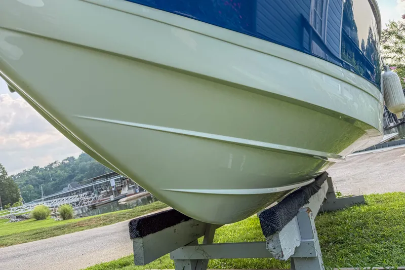 Slide: The Image of 2011 Cobalt 210 boat on stand, near marina, grassy area, sunny day. - 31