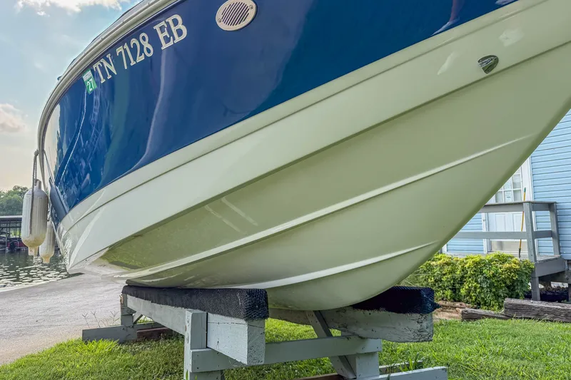 Slide: The Image of 2011 Cobalt 210 boat on stand, blue and white hull, dockside view. - 30