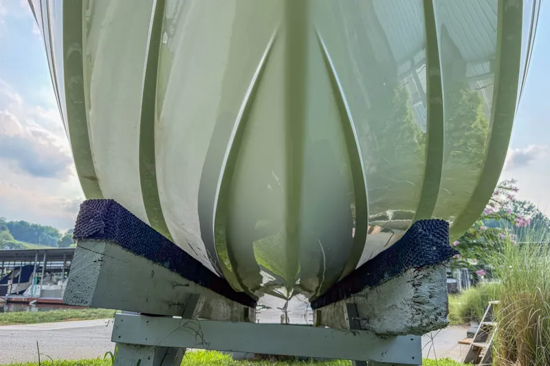 Slide: The Image of Bottom view of a 2011 Cobalt 210 boat hull on a stand, outdoors. - 32