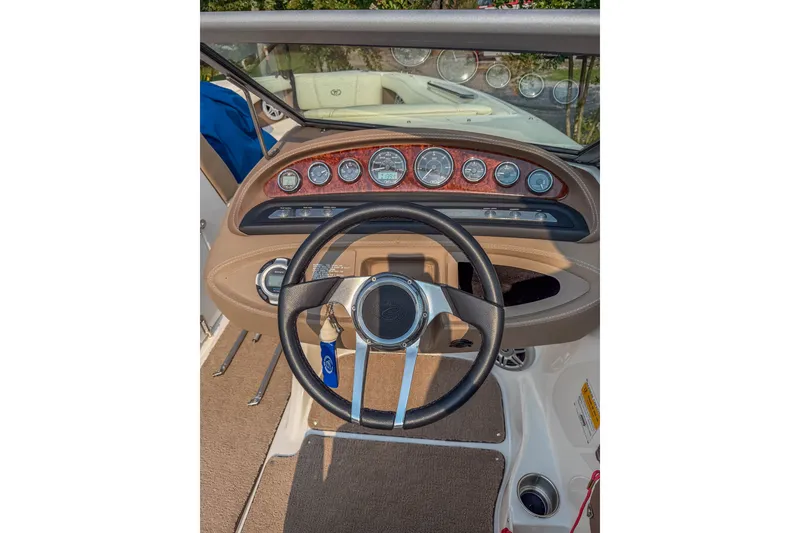 Slide: The Image of Steering wheel and dashboard of a 2011 Cobalt 210 boat, featuring multiple gauges. - 14