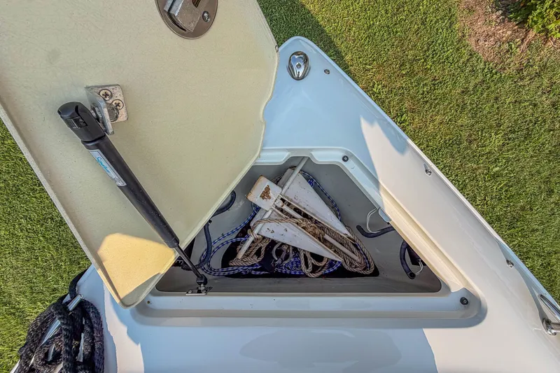 Slide: The Image of Open storage compartment on a 2011 Cobalt 210 boat, containing ropes and anchors. - 9