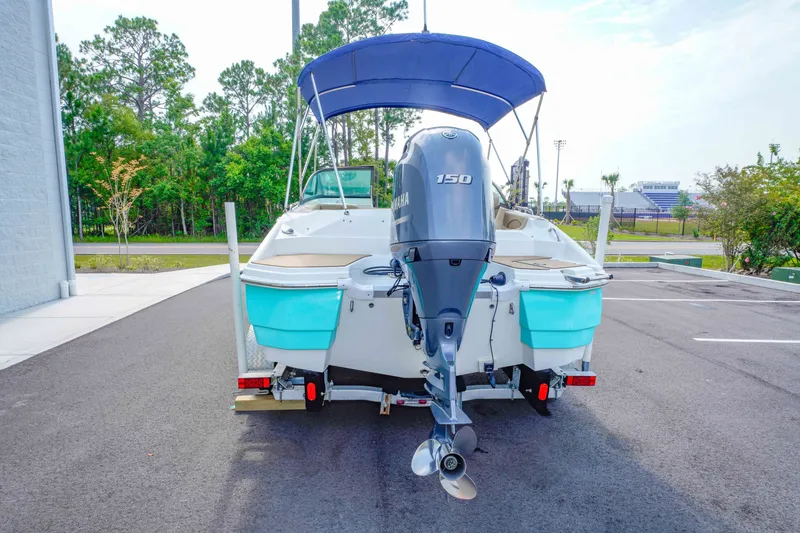 Slide: The Image of 2020 NauticStar 203 DC boat with Yamaha 150 engine, parked outdoors. - 5