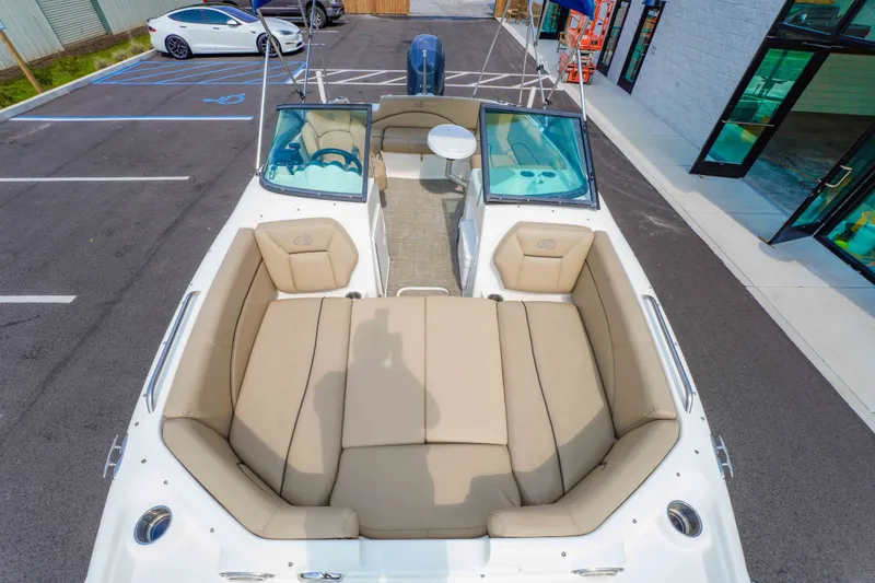 Slide: The Image of 2020 NauticStar 203 DC boat with beige seating, parked in a lot near a building. - 22