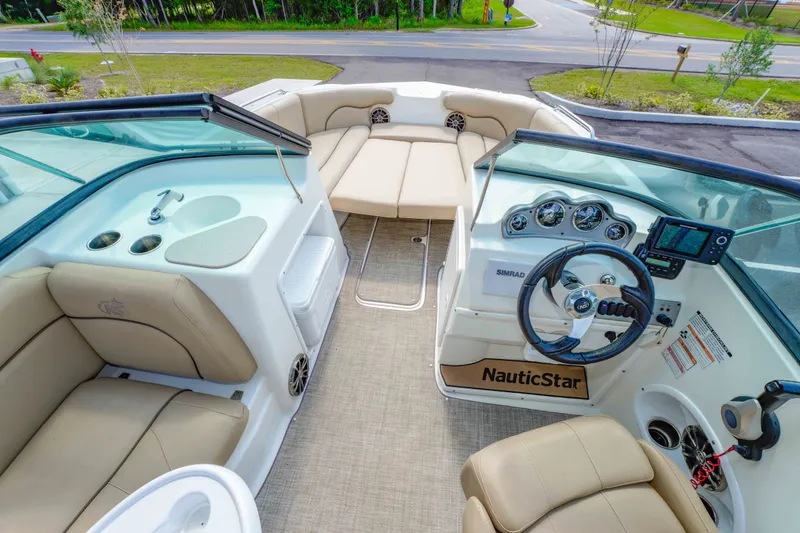 Slide: The Image of Interior view of 2020 NauticStar 203 DC boat with beige seating and modern dashboard. - 17