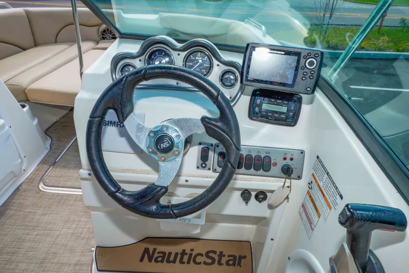 Slide: The Image of Cockpit of 2020 NauticStar 203 DC boat with steering wheel and navigation instruments. - 21