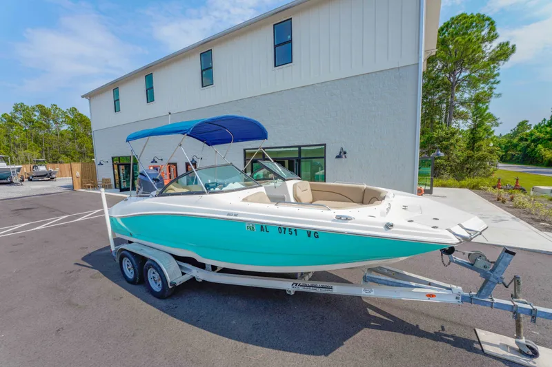 Slide: The Image of 2020 NauticStar 203 DC boat on trailer, parked outside a modern building. - 26