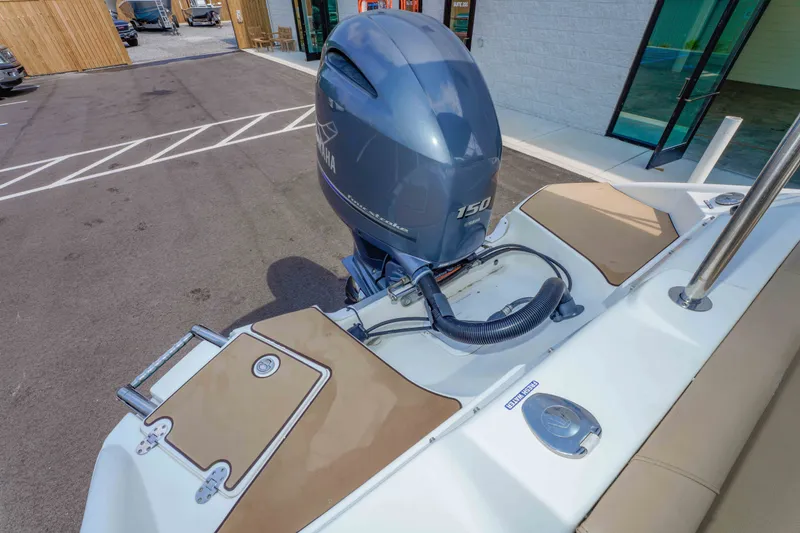 Slide: The Image of 2020 NauticStar 203 DC boat with Yamaha 150 outboard motor in a parking area. - 24
