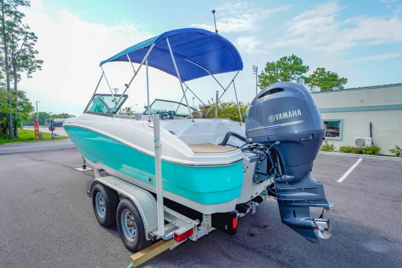 Slide: The Image of 2020 NauticStar 203 DC boat with Yamaha engine on trailer, featuring blue canopy. - 6