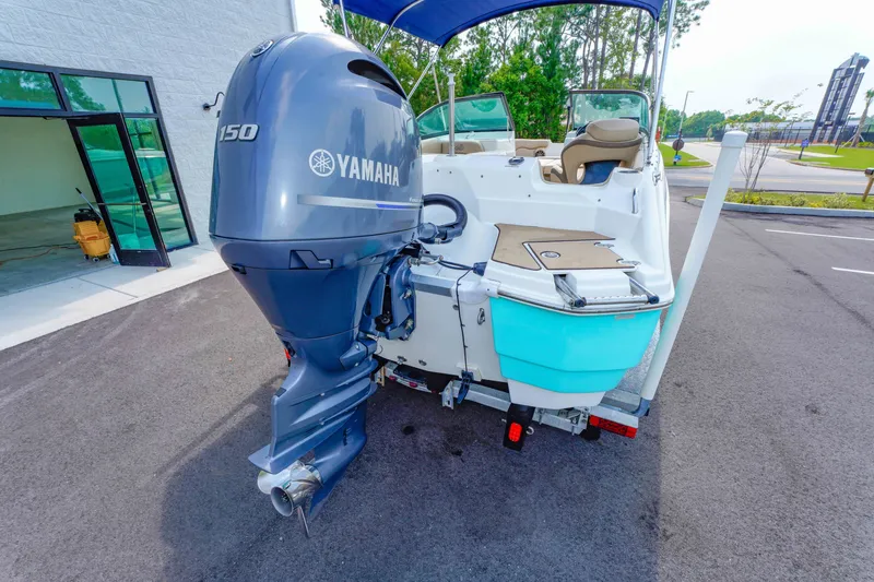 Slide: The Image of 2020 NauticStar 203 DC boat with Yamaha 150 engine, parked outdoors. - 11