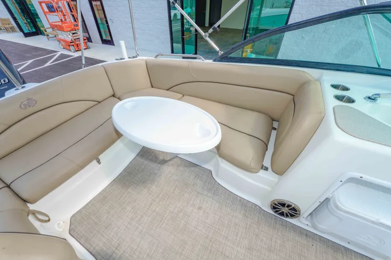 Slide: The Image of 2020 NauticStar 203 DC boat interior with beige seating and white table. - 15