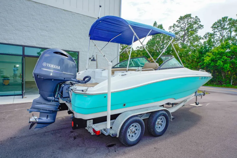 Slide: The Image of 2020 NauticStar 203 DC boat with Yamaha engine on trailer, featuring blue canopy. - 3