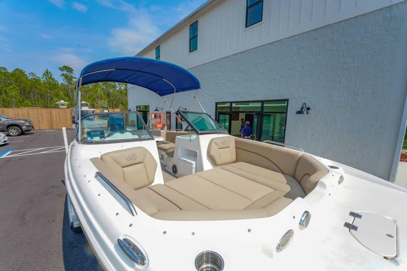 Slide: The Image of 2020 NauticStar 203 DC boat with blue canopy, parked near a building. - 27