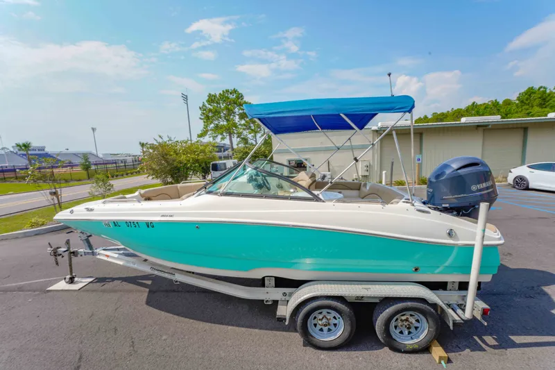Slide: The Image of 2020 NauticStar 203 DC boat on trailer with blue canopy in parking lot. - 29