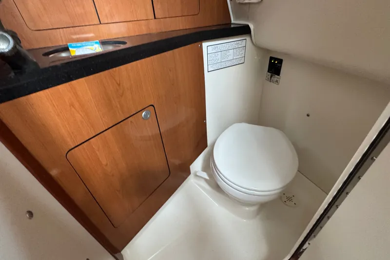 Slide: The Image of Compact bathroom in 2008 Century 3200 Offshore boat with wooden cabinetry and toilet. - 27