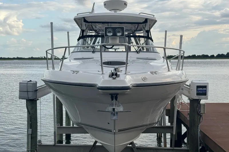 Slide: The Image of 2008 Century 3200 Offshore boat docked on a lift by the water. - 2