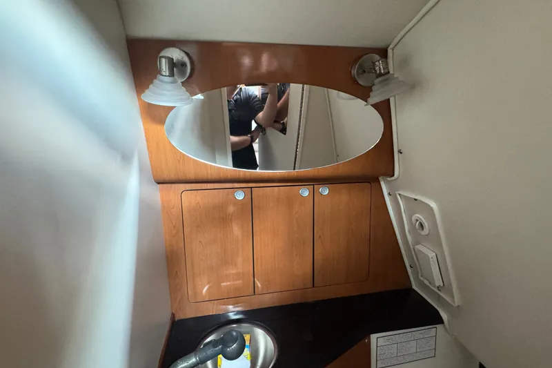 Slide: The Image of 2008 Century 3200 Offshore boat interior with wooden cabinets and oval mirror. - 28