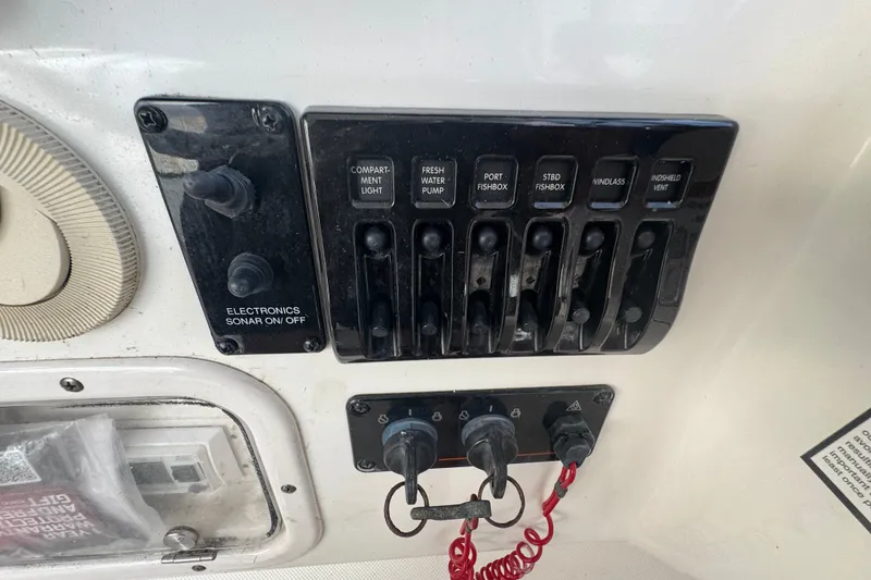 Slide: The Image of Control panel of a 2008 Century 3200 Offshore boat with various switches and keys. - 17