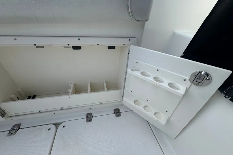 Slide: The Image of Storage compartment on a 2008 Century 3200 Offshore boat, featuring cup holders and secure latch. - 11
