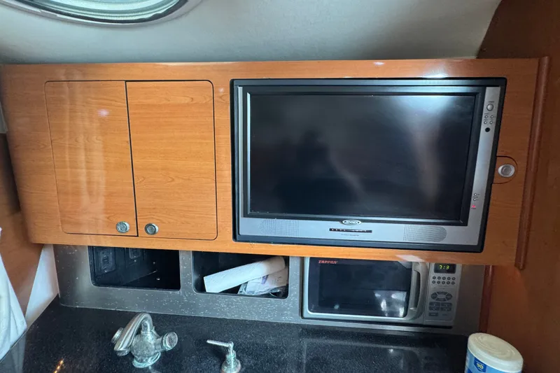 Slide: The Image of 2008 Century 3200 Offshore interior with TV, microwave, and wooden cabinetry. - 22
