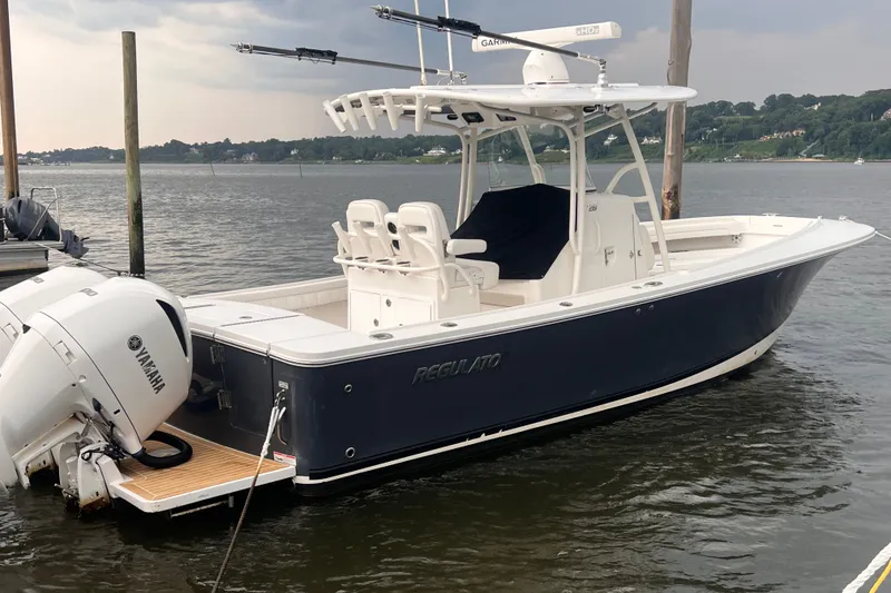Slide: The Image of 2019 Regulator 28 Forward Seating boat docked with Yamaha engines. - 2