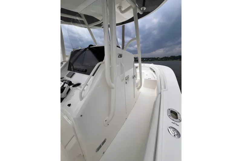 Slide: The Image of 2019 Regulator 28 Forward Seating boat, showcasing sleek design and spacious deck under cloudy skies. - 3