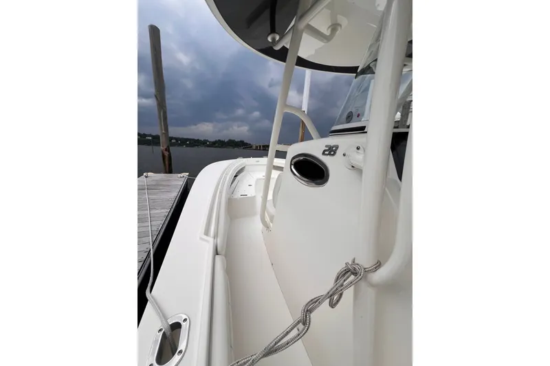 Slide: The Image of 2019 Regulator 28 Forward Seating boat docked, showcasing sleek design and stormy sky backdrop. - 4