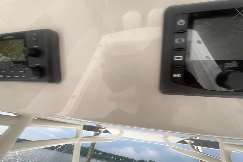 Slide: The Image of Control panel on a 2019 Regulator 28 Forward Seating boat, overlooking water. - 13