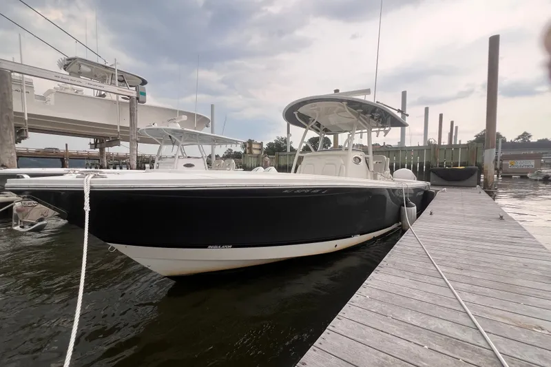 The Image of 2019 Regulator 28 Forward Seating boat docked at marina under cloudy sky. - 1