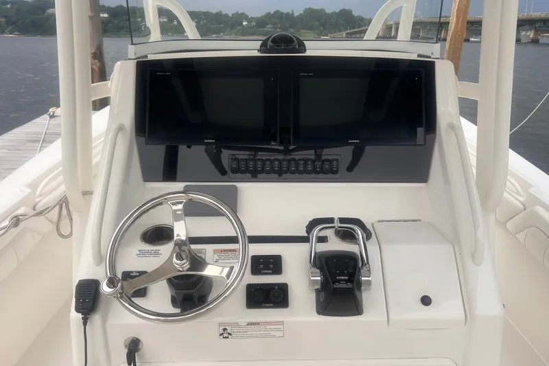 Slide: The Image of Control panel of a 2019 Regulator 28 Forward Seating boat with steering wheel and displays. - 11