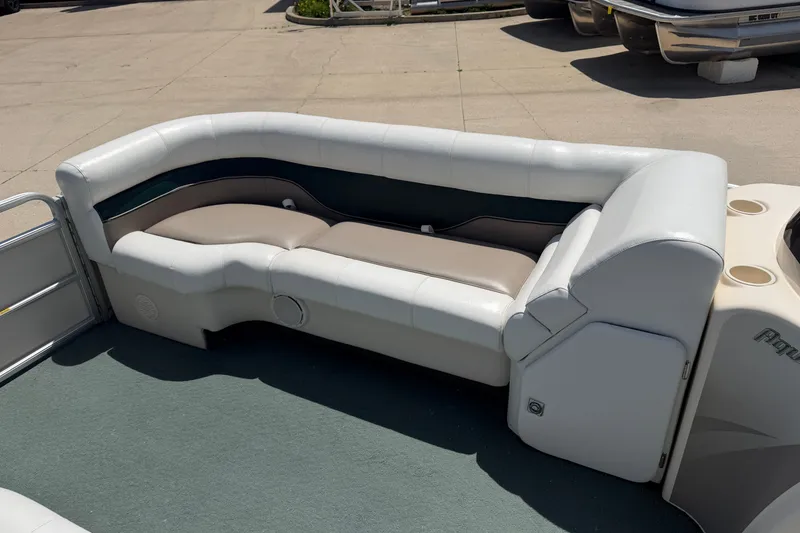Slide: The Image of 2006 Godfrey Aqua Patio boat seating with white and beige upholstery on a sunny day. - 6