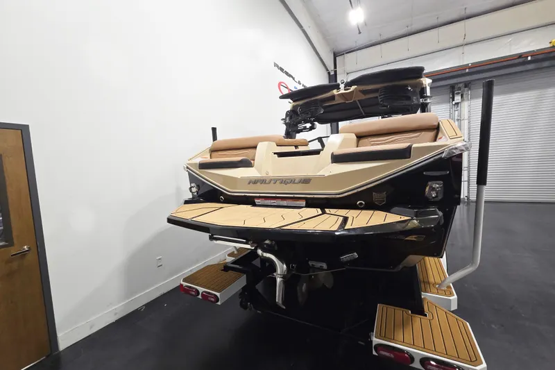 Slide: The Image of 2026 Nautique Super Air Nautique G23 boat in a showroom, rear view. - 4