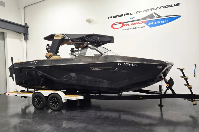 The Image of 2026 Nautique Super Air Nautique G23 boat on trailer in showroom. - 1