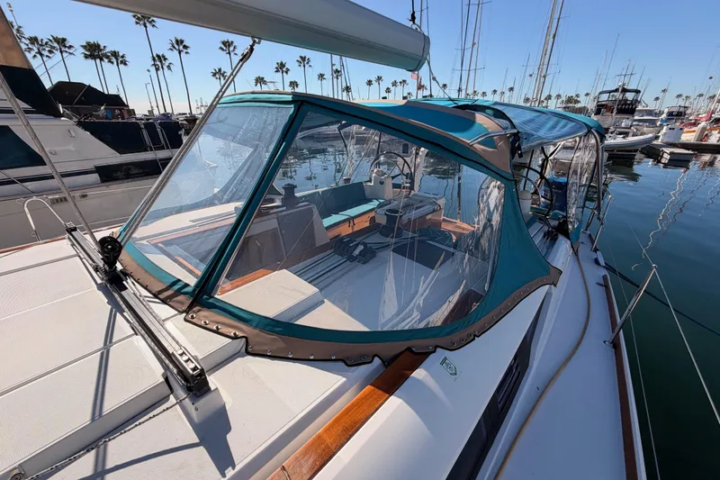 Slide: The Image of 2014 Jeanneau Sun Odyssey 469 sailboat with blue canopy docked in marina. - 25