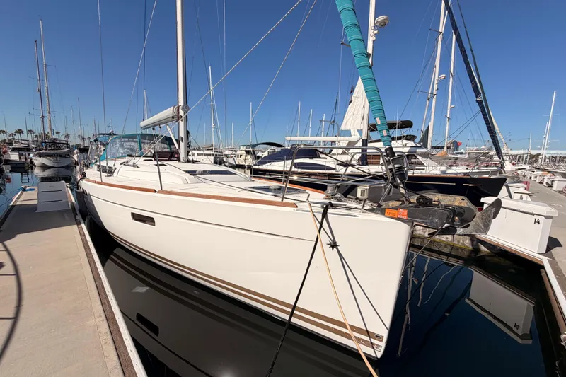 Slide: The Image of 2014 Jeanneau Sun Odyssey 469 sailboat docked in a marina under clear blue skies. - 8
