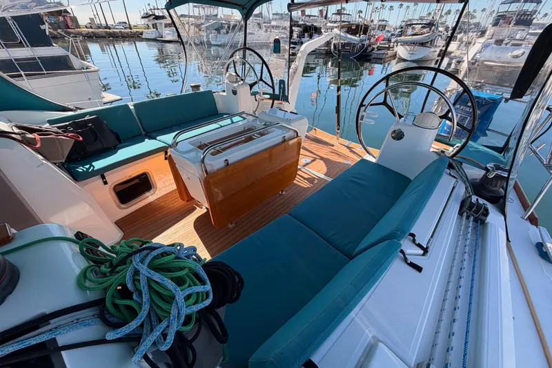 Slide: The Image of 2014 Jeanneau Sun Odyssey 469 sailboat cockpit with teal seating and dual steering wheels. - 26