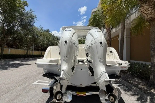 Slide: The Image of Sailfish 276 DC 2027 model with dual outboard engines, parked under palm trees. - 3