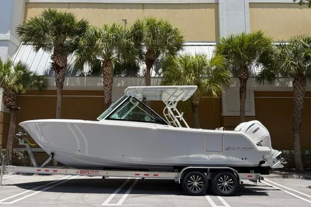 The Image of 2027 Sailfish 276 DC boat on trailer, parked near palm trees. - 0
