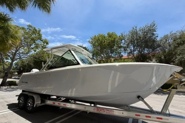 Slide: The Image of 2027 Sailfish 276 DC boat on trailer under clear blue sky. - 2