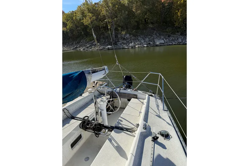 Slide: The Image of 1978 Santana 35 sailboat on calm water near a rocky shoreline. - 9