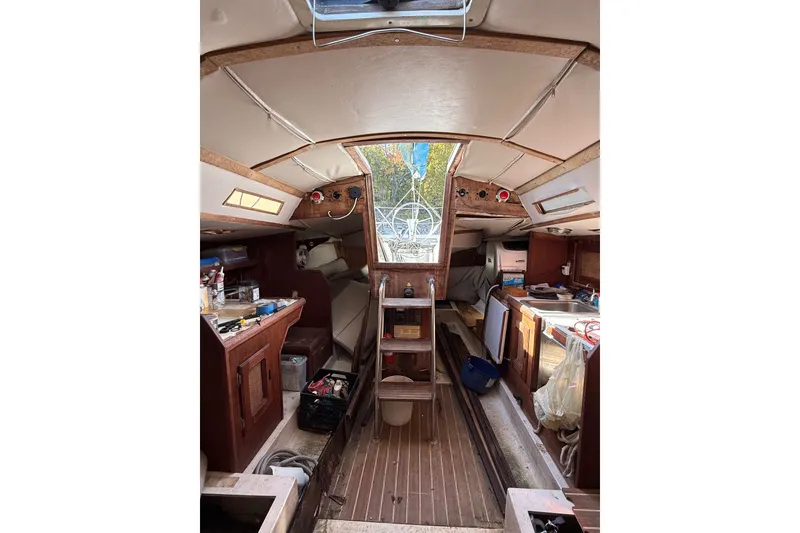 Slide: The Image of Interior of a 1978 Santana 35 sailboat, featuring wooden cabinetry and nautical equipment. - 4