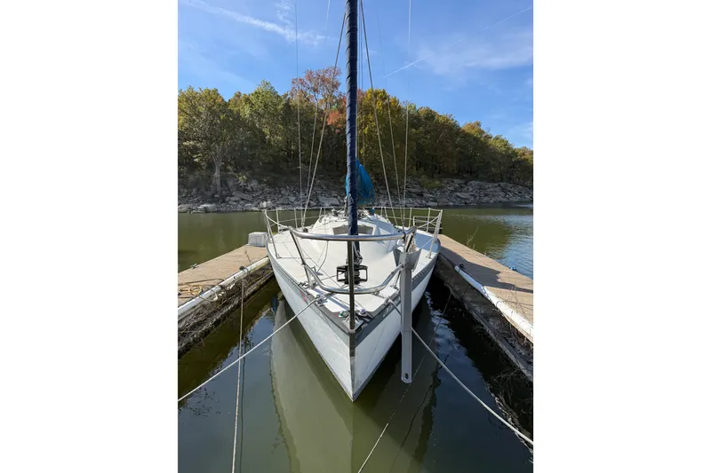 Slide: The Image of 1978 Santana 35 sailboat docked in a serene wooded marina setting. - 3