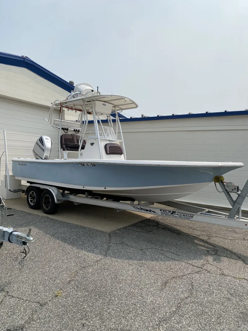 Slide: The Image of A 2018 Tidewater 22 Bay boat on a trailer in front of a building. - 0