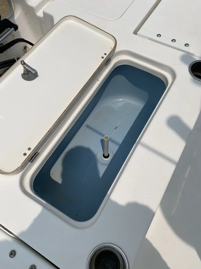 Slide: The Image of An open storage compartment on a boat with a blue interior and a white lid. - 3