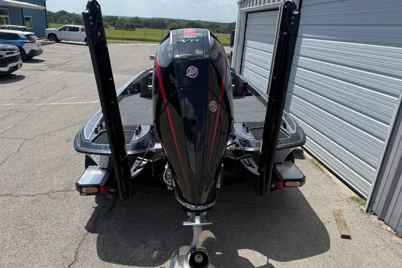Slide: The Image of 2027 Phoenix 921 Elite X boat with powerful outboard motor, parked near a garage. - 6