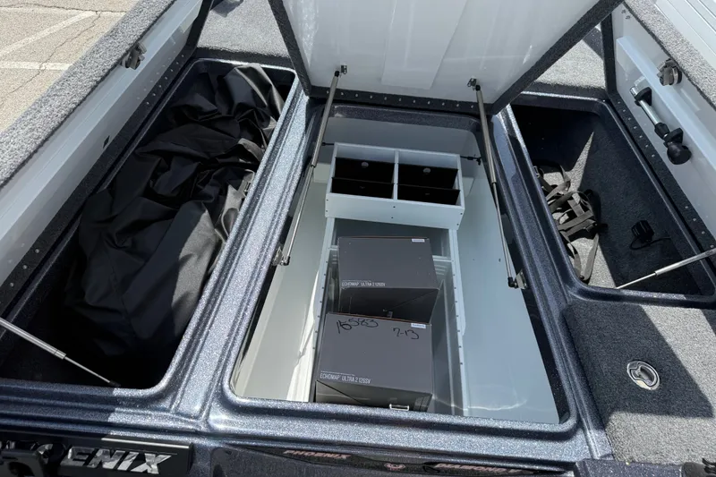 Slide: The Image of Open storage compartments in a 2027 Phoenix 921 Elite X boat. - 13