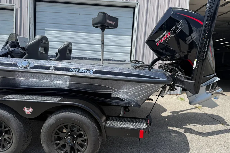 Slide: The Image of 2027 Phoenix 921 Elite X boat with Mercury Pro XS engine, parked outside a garage. - 4