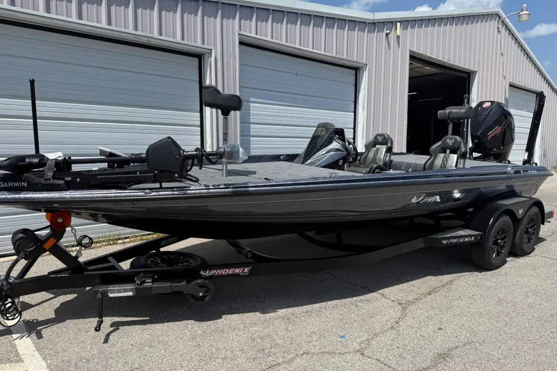 Slide: The Image of 2027 Phoenix 921 Elite X fishing boat parked outside a garage, showcasing sleek design and features. - 5