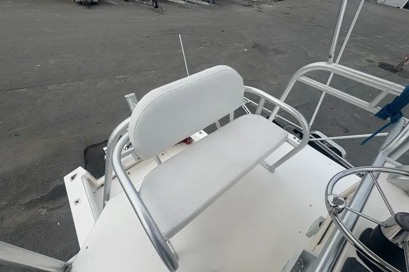 Slide: The Image of 2003 Albemarle 305 Express Fisherman boat seat and helm area, featuring white upholstery and metal frame. - 19