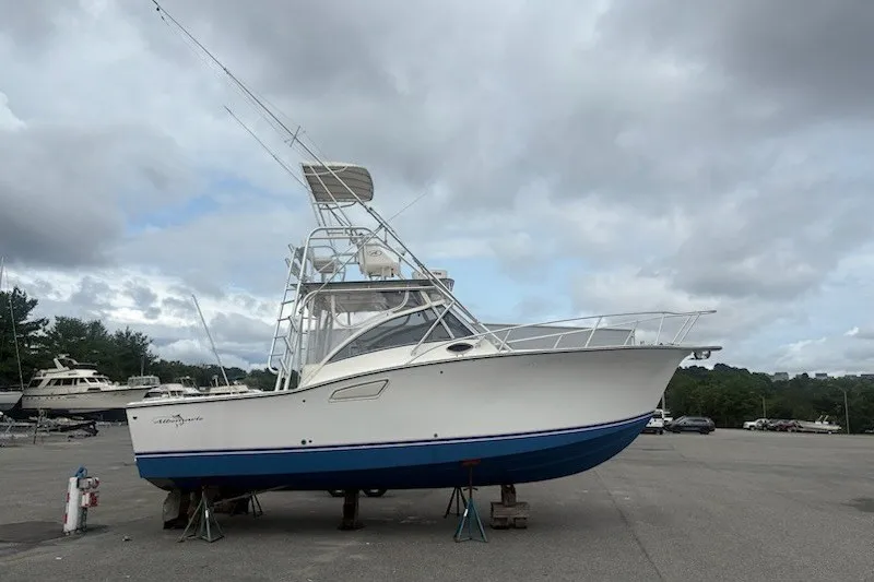 Slide: The Image of 2003 Albemarle 305 Express Fisherman boat on stands, cloudy sky background. - 1