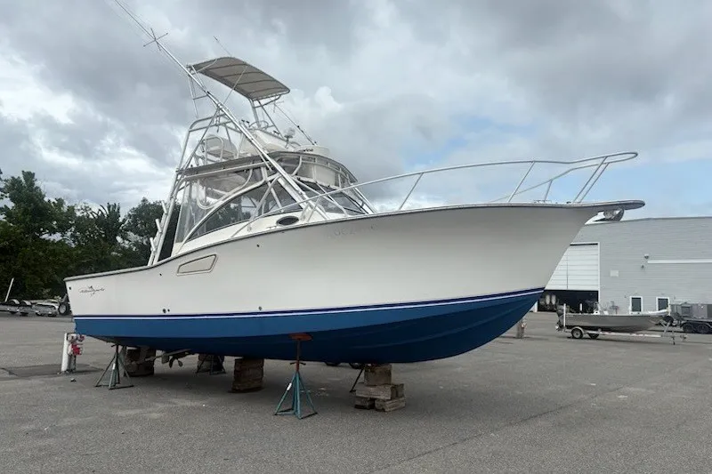 Slide: The Image of 2003 Albemarle 305 Express Fisherman boat on stands, cloudy sky background. - 2